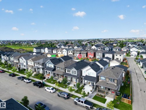 Residential street with diverse architectural styles featuring single-family homes, mature street trees, and concrete sidewalks - 6 Daniel Street, Fort Saskatchewan, AB - Outdoor With View