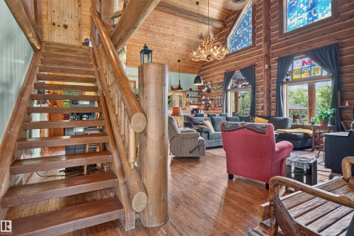 Rustic wood staircase with log newel post and balusters - 107 Idlehours Drive, Rural Barrhead County, AB - Indoor Photo Showing Other Room