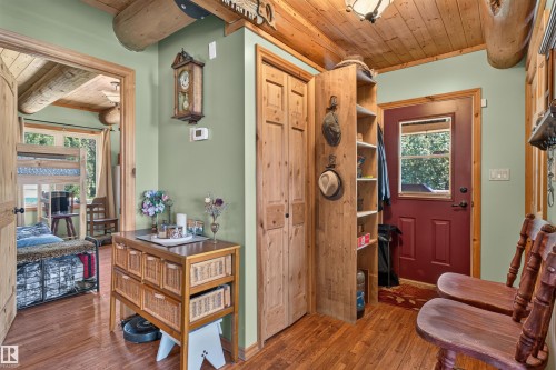 Warm wood-finish flooring complements the light green wall tones - 107 Idlehours Drive, Rural Barrhead County, AB - Indoor Photo Showing Other Room