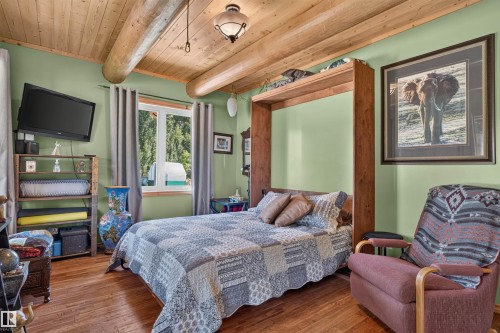 Room featuring wood-finish flooring, exposed wood beams, and a built-in Murphy bed - 107 Idlehours Drive, Rural Barrhead County, AB - Indoor Photo Showing Bedroom