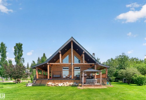 Log home exterior featuring a peaked roofline and prominent front-facing windows - 107 Idlehours Drive, Rural Barrhead County, AB - Outdoor With Deck Patio Veranda