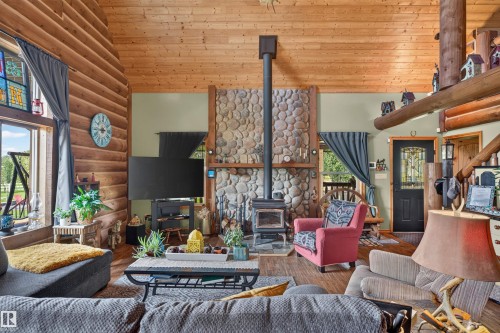 Vaulted wood-paneled ceiling with exposed beams - 107 Idlehours Drive, Rural Barrhead County, AB - Indoor Photo Showing Living Room With Fireplace