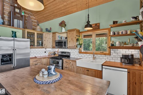 Kitchen featuring a wood-finish island, knotty wood cabinetry, stainless steel appliances, and a farmhouse sink - 107 Idlehours Drive, Rural Barrhead County, AB - Indoor Photo Showing Kitchen