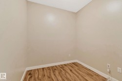 Room featuring wood-finish flooring, light-toned walls, and white baseboards - 
