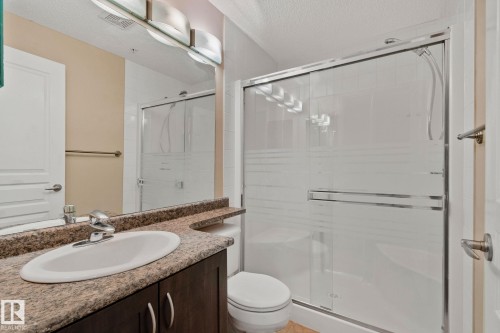Enclosed shower with frosted glass doors - #120 8931 156 St Nw, Edmonton, AB - Indoor Photo Showing Bathroom