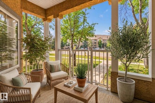 Covered porch featuring a textured ceiling, a white window frame, and a white baluster railing - #120 8931 156 St Nw, Edmonton, AB - Outdoor With Deck Patio Veranda With Exterior
