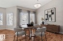 Vaulted ceiling with a flush-mount light fixture, wood-finish flooring, and multiple windows - #120 8931 156 St Nw, Edmonton, AB 