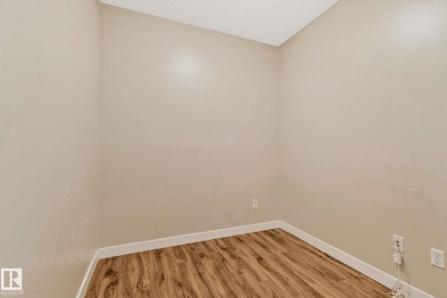 Room featuring wood-finish flooring, light-toned walls, and white baseboards - #120 8931 156 St Nw, Edmonton, AB - Indoor Photo Showing Other Room