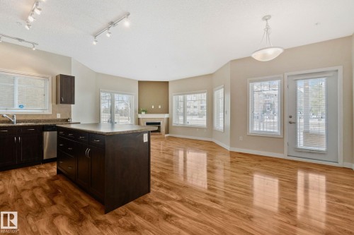 Open-concept living space featuring wood-finish flooring throughout - #120 8931 156 St Nw, Edmonton, AB - Indoor Photo Showing Kitchen