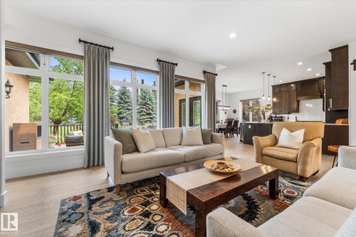 Bright open-concept living area featuring light wood-finish flooring, recessed lighting, and large windows with transom details - #52 Riverstone Close, Rural Sturgeon County, AB - Indoor Photo Showing Living Room