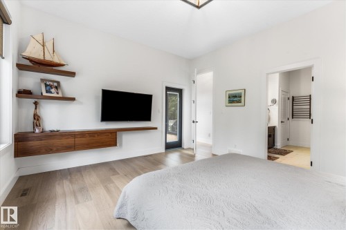 Light wood-finish flooring complements white walls - #52 Riverstone Close, Rural Sturgeon County, AB - Indoor Photo Showing Bedroom