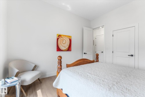 Light wood-finish flooring complements crisp white walls - #52 Riverstone Close, Rural Sturgeon County, AB - Indoor Photo Showing Bedroom