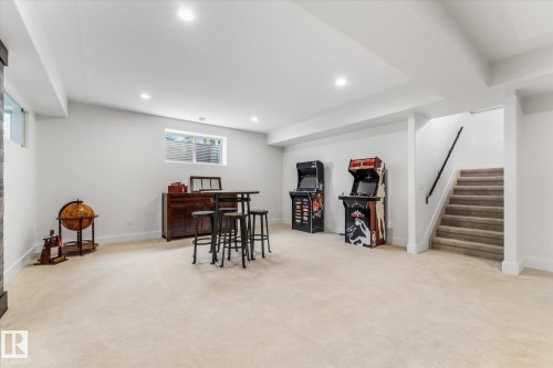 Spacious lower level featuring recessed lighting, a carpeted floor, and a full staircase with a black handrail - #52 Riverstone Close, Rural Sturgeon County, AB - Indoor