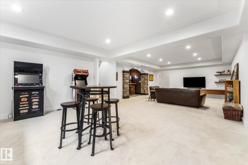 Spacious finished lower level featuring recessed lighting, light-toned carpeting, and a built-in stone-accented bar area - #52 Riverstone Close, Rural Sturgeon County, AB - Indoor