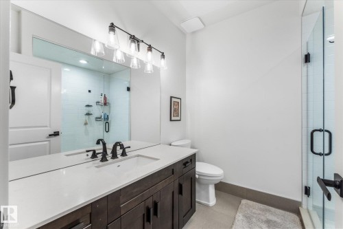 Bathroom featuring a dark wood-finish vanity with a light countertop, a rectangular undermount sink, and a black faucet - #52 Riverstone Close, Rural Sturgeon County, AB - Indoor Photo Showing Bathroom