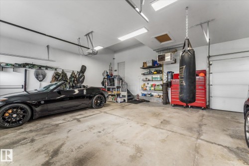 Spacious two-car garage featuring a concrete floor, white walls, and overhead lighting - #52 Riverstone Close, Rural Sturgeon County, AB - Indoor Photo Showing Garage