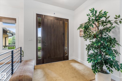 Entryway featuring a dark wood door with vertical panels, clear glass sidelights, and a brushed nickel handle - #52 Riverstone Close, Rural Sturgeon County, AB - Indoor
