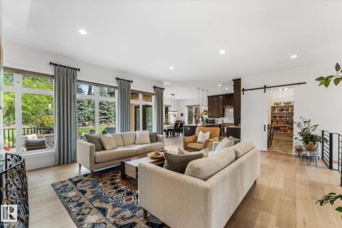 Open-concept living area featuring light wood-finish flooring, recessed lighting, and large windows with outdoor access - #52 Riverstone Close, Rural Sturgeon County, AB - Indoor Photo Showing Living Room