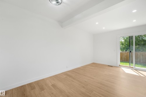 Bright interior space featuring wood-finish flooring, white baseboards, and clean white walls - #39 14511 52 Street Nw, Edmonton, AB - Indoor Photo Showing Other Room