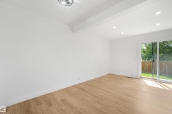 Bright interior space featuring wood-finish flooring, white baseboards, and clean white walls - 