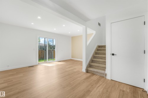 Open-concept living area featuring wood-finish flooring, recessed lighting, and a sliding glass door to the exterior - #39 14511 52 Street Nw, Edmonton, AB - Indoor Photo Showing Other Room