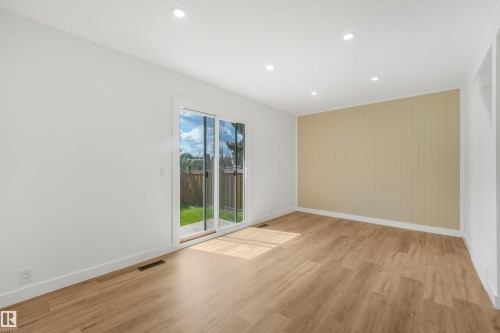 Spacious room featuring wood-finish flooring, recessed lighting, and a neutral color palette - #39 14511 52 Street Nw, Edmonton, AB - Indoor Photo Showing Other Room