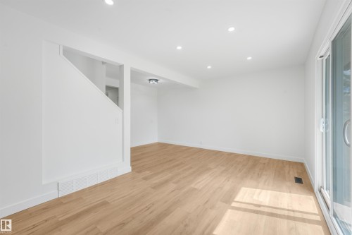 Bright room featuring light wood-finish flooring, white baseboards, and a white wall finish - #39 14511 52 Street Nw, Edmonton, AB - Indoor Photo Showing Other Room