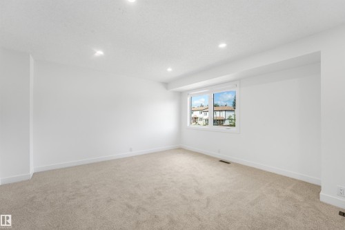 Bright interior space featuring a double-paned window, recessed lighting, neutral carpeting, white baseboards, and a white ceiling - #39 14511 52 Street Nw, Edmonton, AB - Indoor Photo Showing Other Room