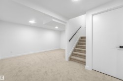 Carpeted staircase with black handrail - 