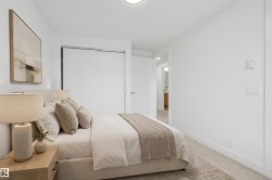 Recessed ceiling lighting illuminates a room featuring a carpeted floor, white walls, and a closet with sliding doors - 
