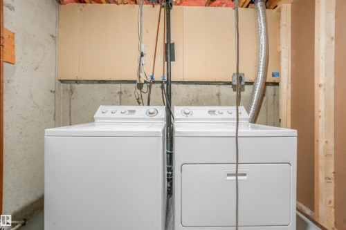 Dedicated laundry area featuring a white top-load washing machine and a white front-load dryer - #39 14511 52 Street Nw, Edmonton, AB - Indoor Photo Showing Laundry Room