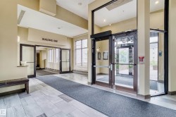 Building entrance featuring glass doors, light-toned wall finishes, and recessed lighting - 