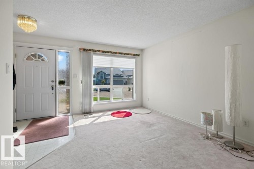Entry foyer with white door, transom window, and frosted sidelight - 1046 Jones Crescent Nw, Edmonton, AB - Indoor