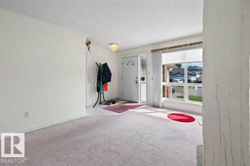 Bright living area with light-toned wall paint and textured ceiling - 1046 Jones Crescent Nw, Edmonton, AB - Indoor Photo Showing Other Room