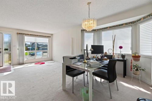 Bright interior space featuring light-toned carpeting and a textured ceiling - 1046 Jones Crescent Nw, Edmonton, AB - Indoor Photo Showing Dining Room