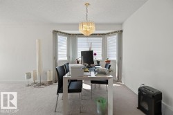Recessed bay window with multiple vertical blinds, complemented by a gold-toned chandelier - 