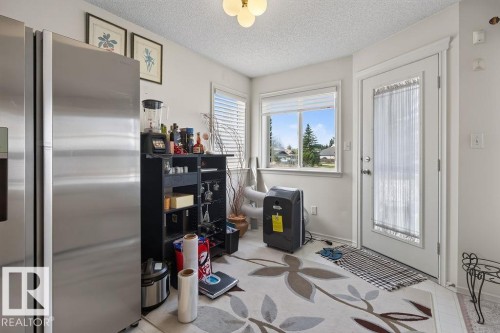 Kitchen nook featuring an exterior door with frosted glass paneling, a large window with white blinds, and a built-in ceiling light fixture - 1046 Jones Crescent Nw, Edmonton, AB - Indoor Photo Showing Other Room
