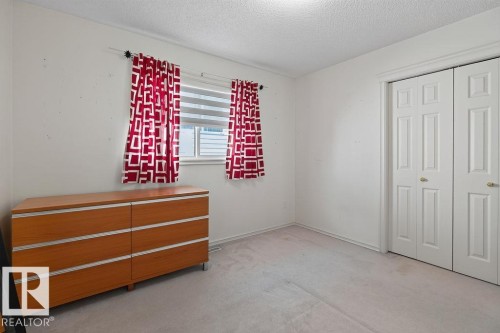 Light-colored carpeted flooring with a contrasting white trim, featuring a double-pane window with horizontal blinds - 1046 Jones Crescent Nw, Edmonton, AB - Indoor