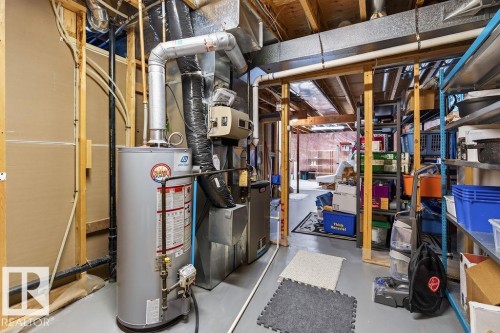 Utility room featuring a water heater, furnace, and exposed ceiling joists - 1046 Jones Crescent Nw, Edmonton, AB - Indoor Photo Showing Basement