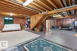 Open basement space featuring exposed wood joists, concrete flooring, and visible ductwork - 