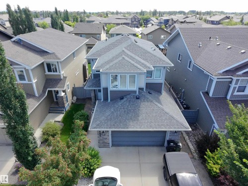 Contemporary residence featuring a multi-tone exterior, attached garage, and prominent front-facing windows - 8719 218 Street Nw, Edmonton, AB - Outdoor With Facade
