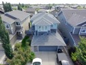 Contemporary residence featuring a multi-tone exterior, attached garage, and prominent front-facing windows - 8719 218 Street Nw, Edmonton, AB  - Outdoor With Facade 