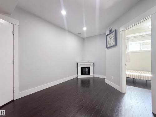 Room featuring dark wood-finish flooring, light grey wall paint, and white baseboards - 8719 218 Street Nw, Edmonton, AB - Indoor Photo Showing Other Room
