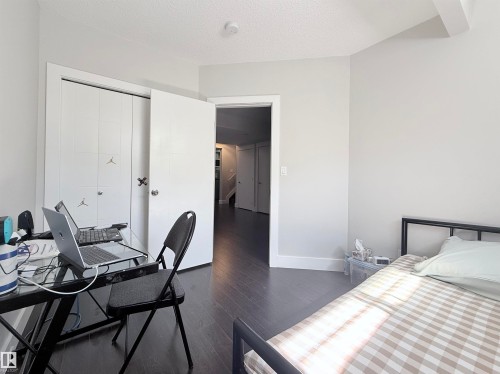 Interior room featuring dark wood-finish flooring, light-colored walls, and a white ceiling - 8719 218 Street Nw, Edmonton, AB - Indoor Photo Showing Bedroom