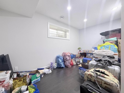 Lower-level room featuring light gray walls, dark wood-finish flooring, and a window with white trim - 8719 218 Street Nw, Edmonton, AB - Indoor