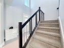 Carpeted staircase with dark wood newel posts and railings featuring metal balusters - 8719 218 Street Nw, Edmonton, AB  - Indoor Photo Showing Other Room 