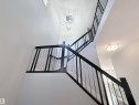 Two-story staircase featuring contemporary dark wood handrails with metal balusters - 8719 218 Street Nw, Edmonton, AB  - Indoor Photo Showing Other Room 