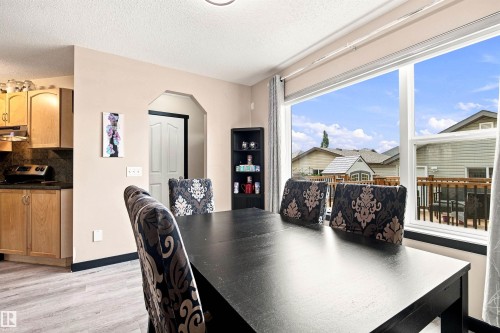 Kitchen with light wood-finish cabinetry and dark stone-look countertops - 204 59 Street Sw, Edmonton, AB - Indoor Photo Showing Dining Room