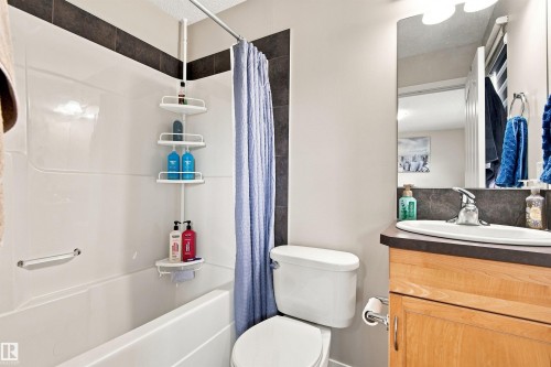 White acrylic bathtub with a grab bar - 204 59 Street Sw, Edmonton, AB - Indoor Photo Showing Bathroom