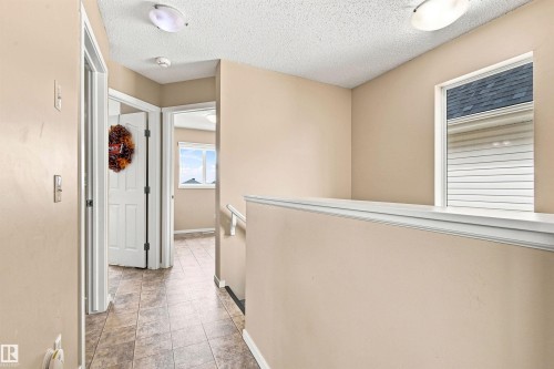 Textured ceiling, flush mount ceiling lights, neutral wall paint, tile flooring, and white trim - 204 59 Street Sw, Edmonton, AB - Indoor Photo Showing Other Room